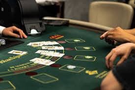 Professional blackjack dealer at live table with cards and betting layout